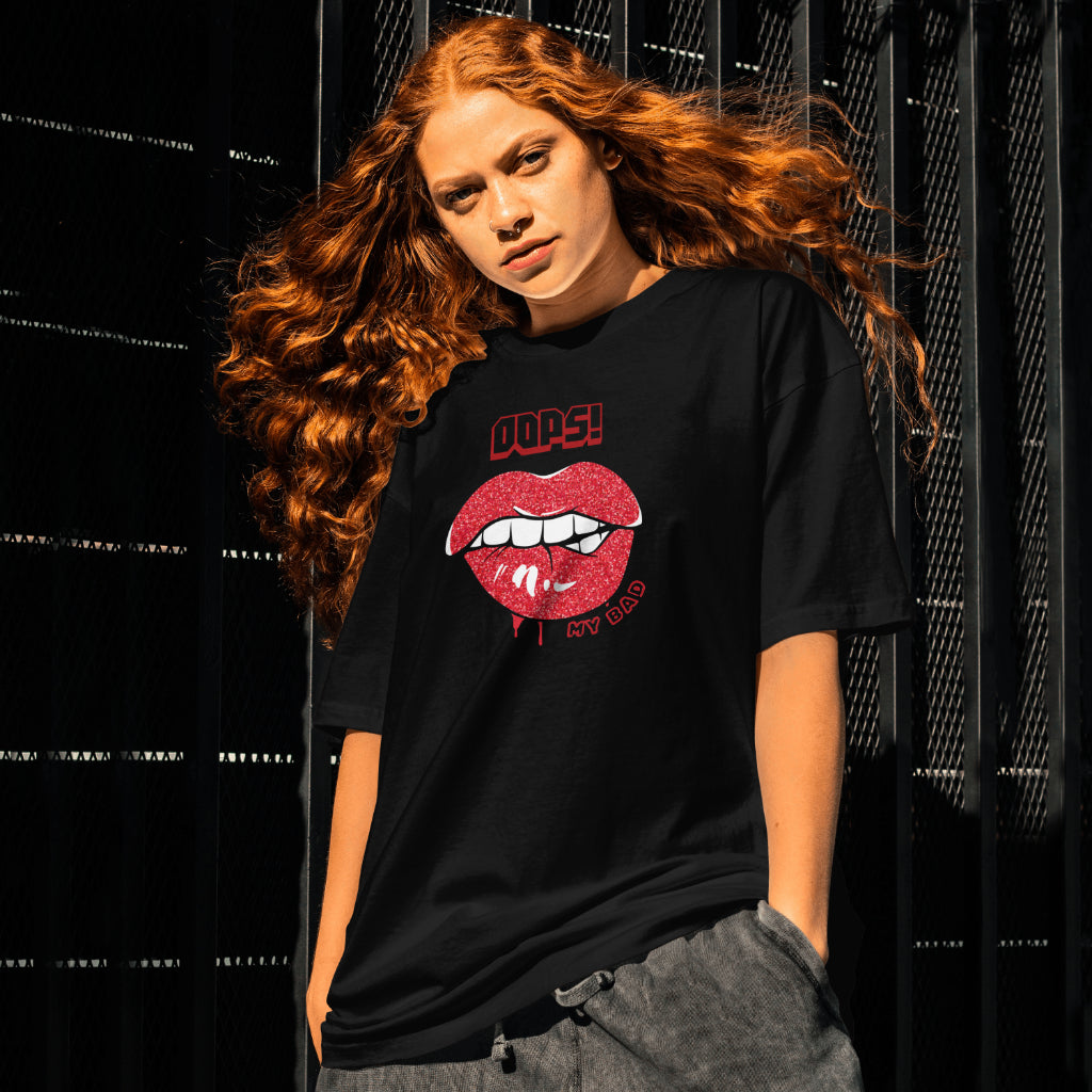 A female model standing wearing 'Oops My Bad' graphic oversized tshirt in black