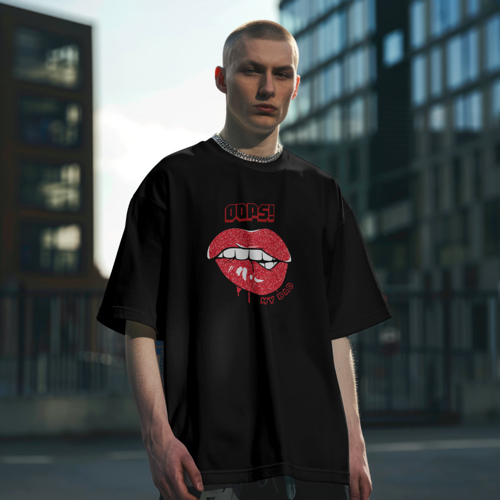 A male model standing straight wearing 'Oops My Bad' graphic oversized tshirt in black