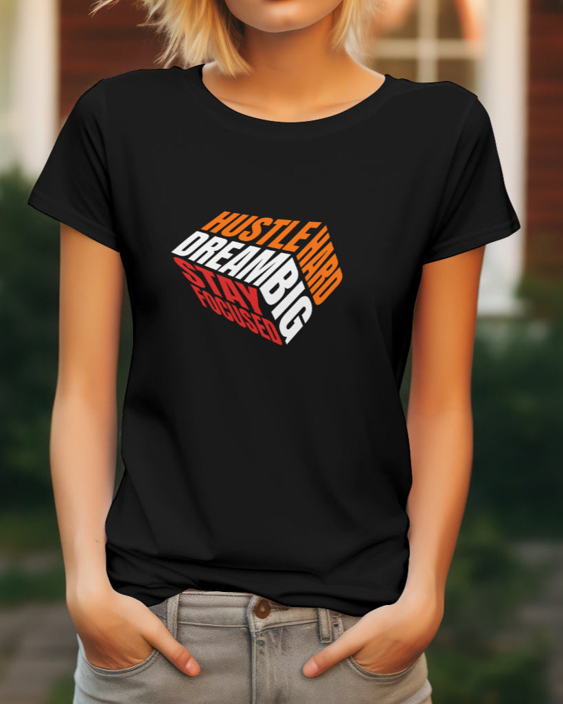 a female model standing with her hands in her pockets wearing a Hustle Hard Dream Big Stay Focused Tshirt in Black color