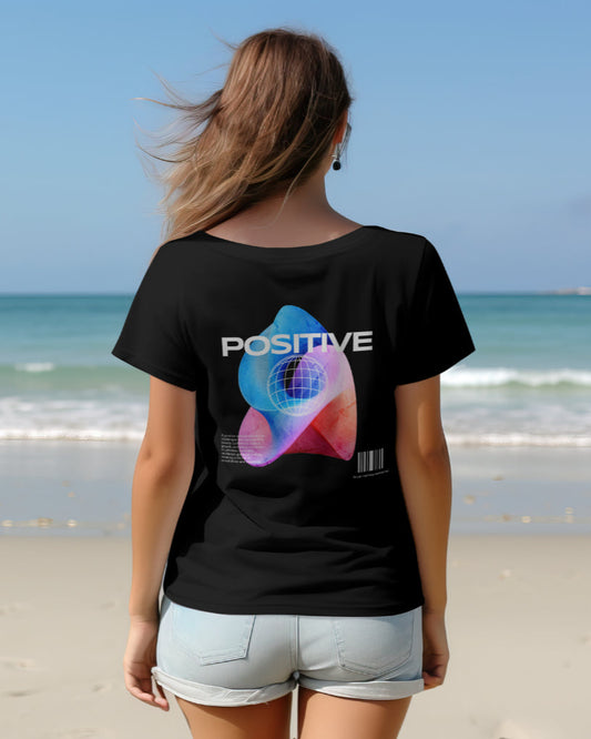 back view of a female model on a beach wearing Cosmic Positive black tshirt