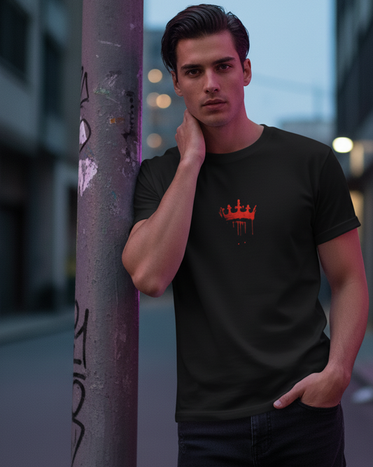 Man wearing a black t-shirt with a red  King movie logo against an urban background