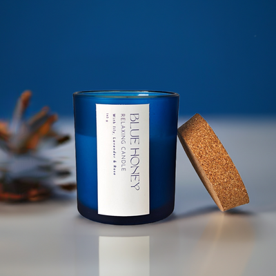 Blue frosted soy wax candle with a cork lid, featuring a 'Blue Honey' label with relaxing scents.