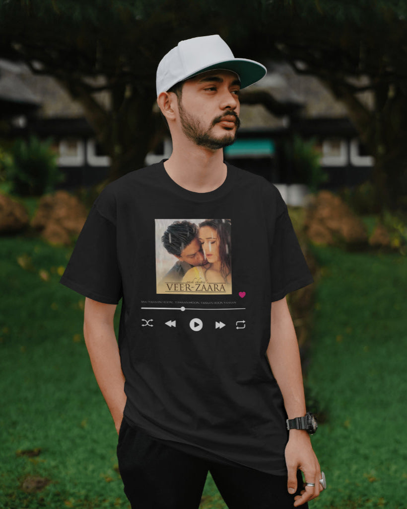 A male model with a white cap wearing oversized Unisex 'Veer Zaara Graphic' Black T-shirt