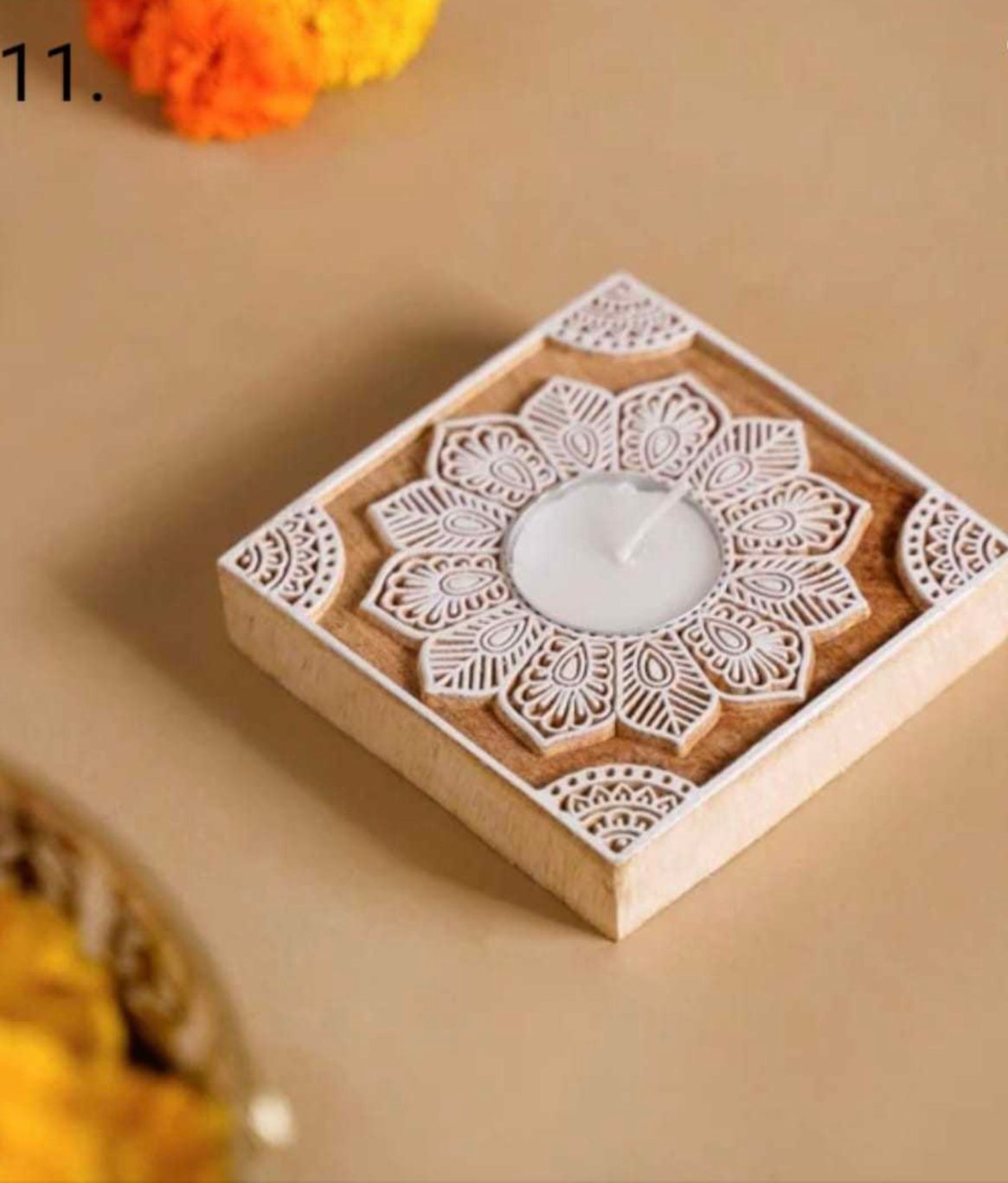 Decorative candle holder with floral patterns on a beige surface