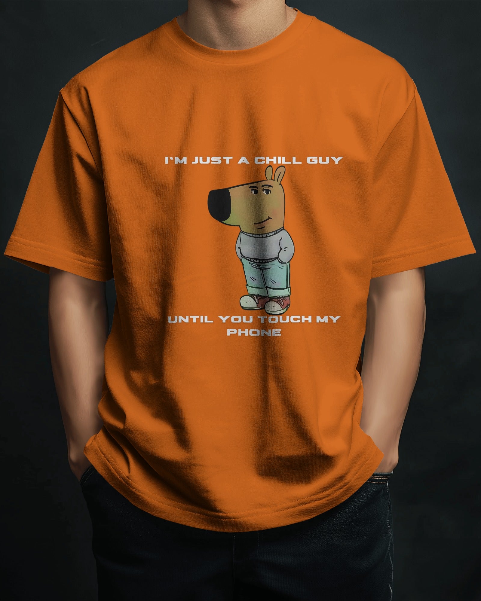 a male model standing with his hands in his pockets wearing an orange "I’m Just a Chill Guy… Until You Touch My Phone" tshirt