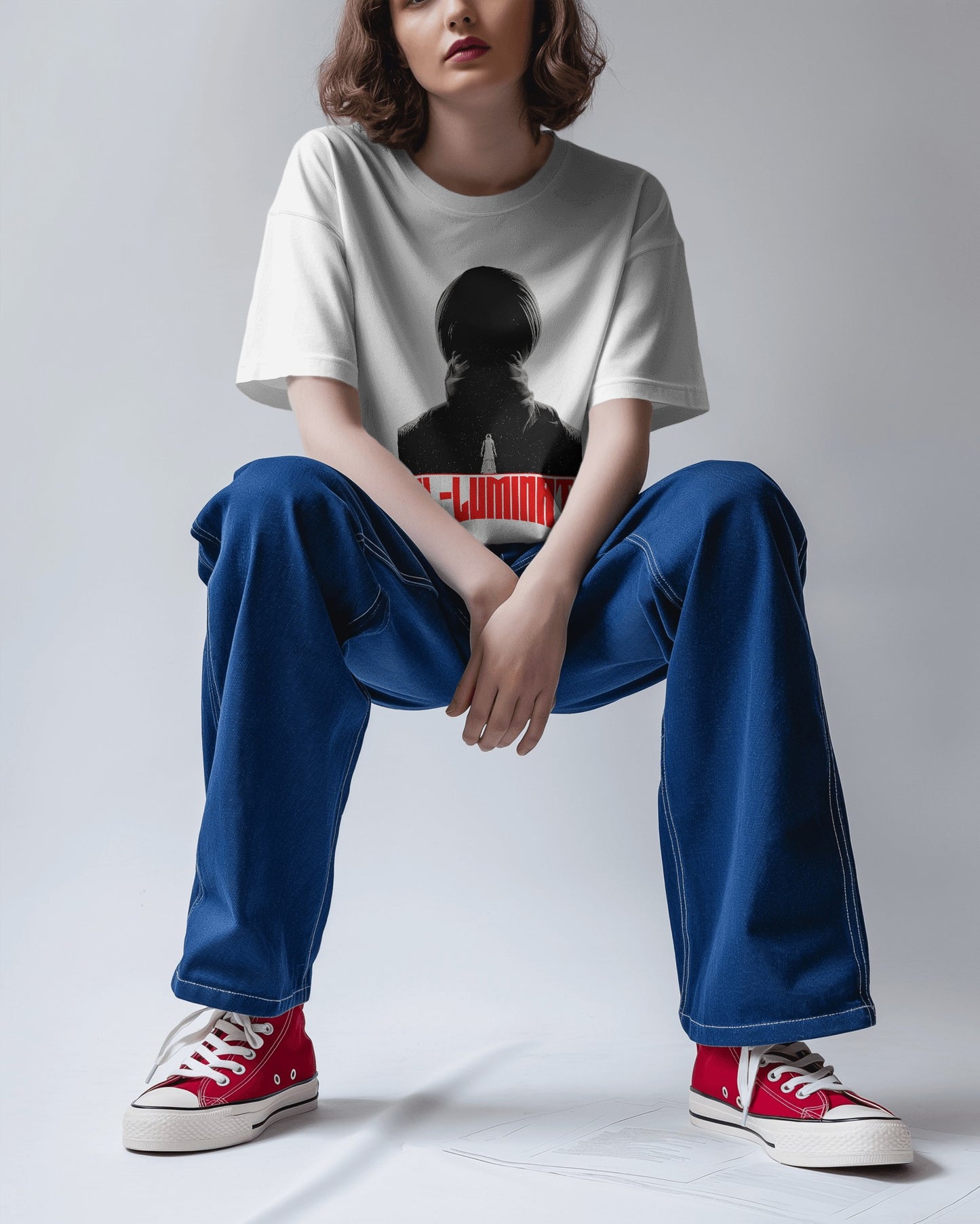 an Asian female model sitting wearing an Oversized Diljit Dosanjh "Diluminati" T-Shirt white