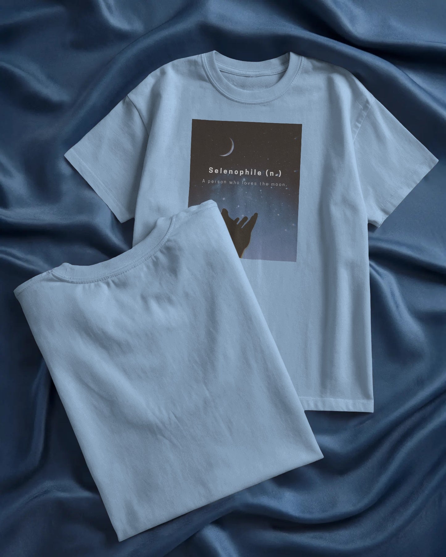 oversized baby blue Selenophile tshirt laying on a blue sheet in the background