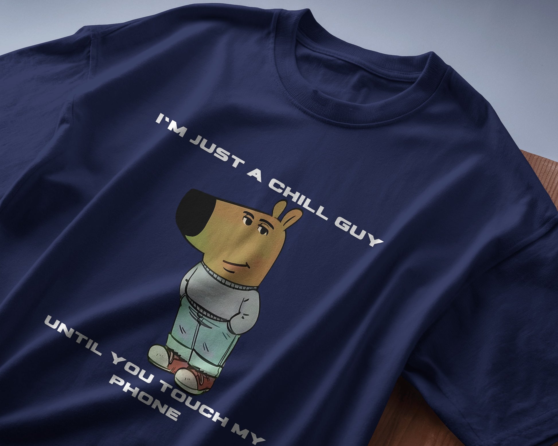 navy blue "I’m Just a Chill Guy… Until You Touch My Phone" tshirt laying on the table