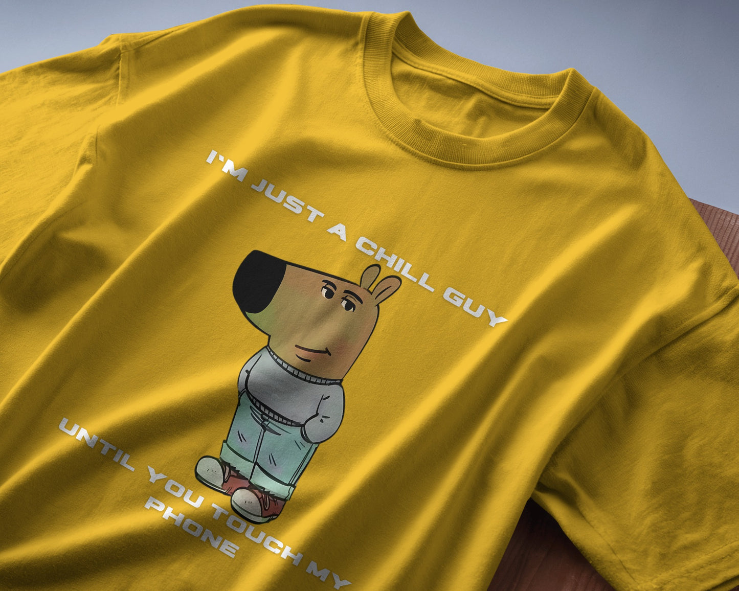 yellow "I’m Just a Chill Guy… Until You Touch My Phone" tshirt laying on the table