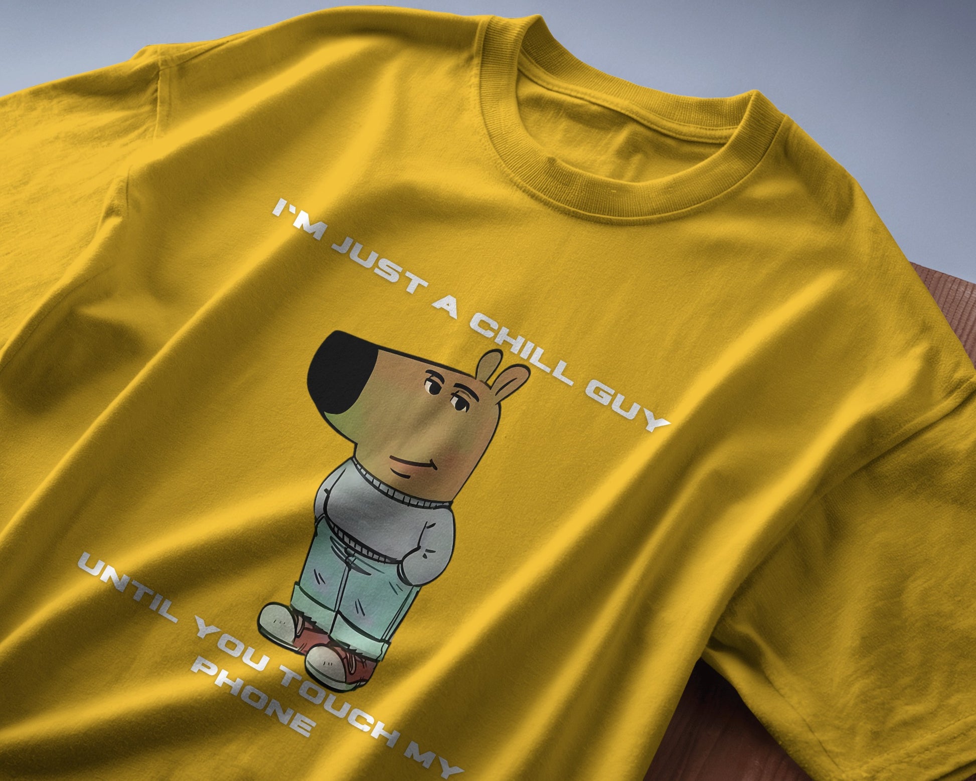 yellow "I’m Just a Chill Guy… Until You Touch My Phone" tshirt laying on the table