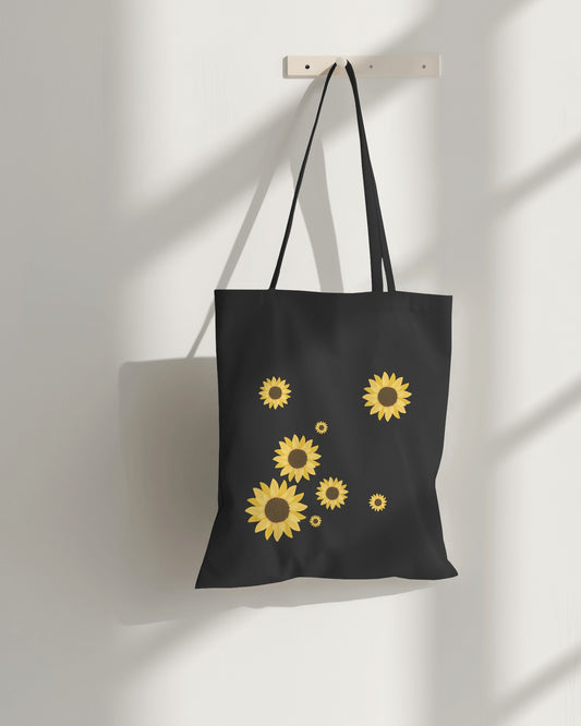 a black sunflower tote bag with zipper on a hanger