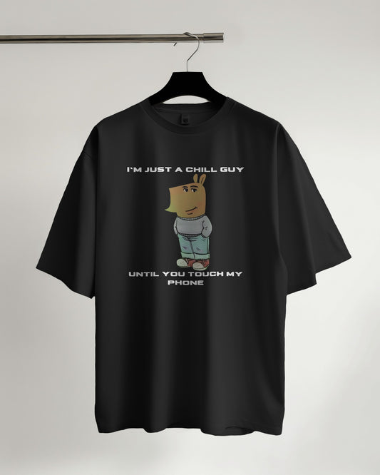 "I’m Just a Chill Guy… Until You Touch My Phone" black tshirt on a hanger with white background