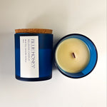 Blue Honey relaxing candle in a frosted blue glass jar with a cork lid, viewed from above.