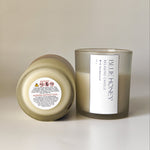 Close-up of a frosted soy wax candle with a label showing 'Blue Honey Relaxing Candle With Sandalwood'.