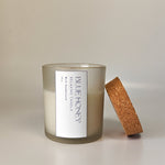 Frosted glass jar candle with cork lid, featuring a 'Blue Honey' label with sandalwood scent.