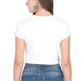 Back view of a woman wearing a white short-sleeved crop top and blue denim jeans.