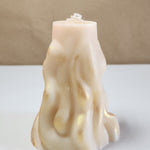 A 4" x 9.5" white 3D wave soy wax pillar candle with gold shimmer, front view.