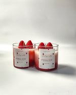Two Eternal Rose and Strawberry scented soy wax candles in glass jars, front view, with strawberry decorations.