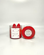 Eternal Rose scented soy wax candle in a glass jar, topped with fresh strawberries.