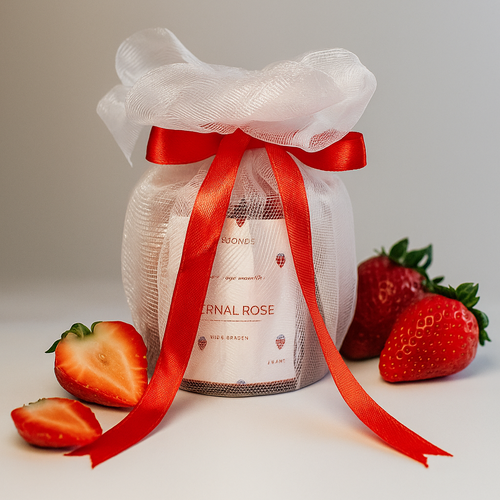Eternal Rose scented soy wax candle gift-wrapped with red ribbon and strawberries, front view.