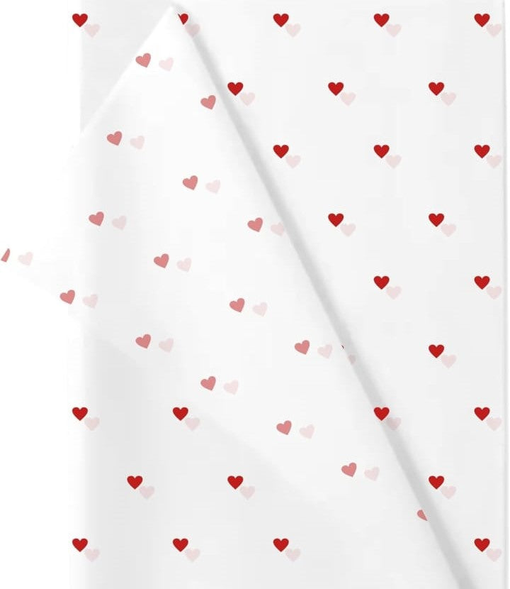 White gift wrap featuring a repeating pattern of small red and pink hearts, perfect for Valentine's Day or any occasion.