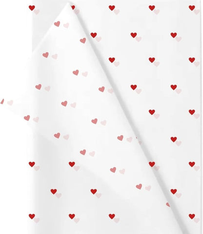 White gift wrap featuring a repeating pattern of small red and pink hearts, perfect for Valentine's Day or any occasion.