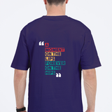 Back view of a unisex oversized navy blue t-shirt with colorful modern typography reading 'A Moment on the Lips, Forever on the Hips'.