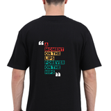 Back view of a black oversized unisex t-shirt with a colorful modern typography quote 'A moment on the lips, forever on the hips'.