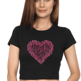 Front view of a black crop top with a pink heart made of X's and O's on the chest.