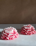 Set of two rose-scented peony flower soy wax candles, detailed with layered petals and a pink hue.
