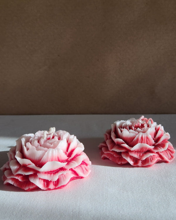Set of two rose-scented peony flower soy wax candles, detailed with layered petals and a pink hue.