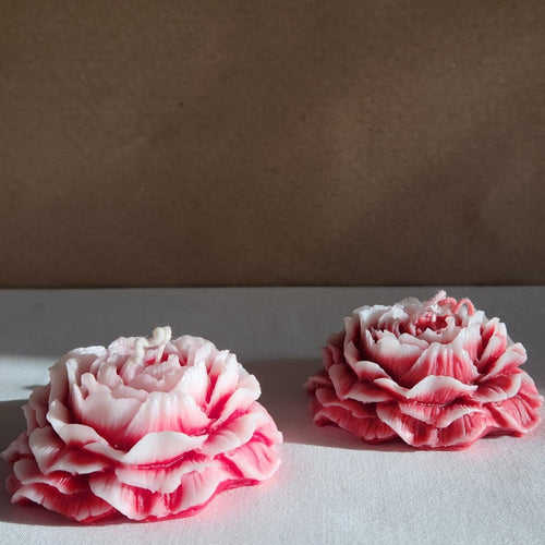 Set of two rose-scented peony flower soy wax candles, detailed with layered petals and a pink hue.