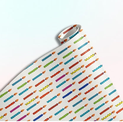 Rolled gift wrap featuring a repeating pattern of colorful birthday candles on a white background.