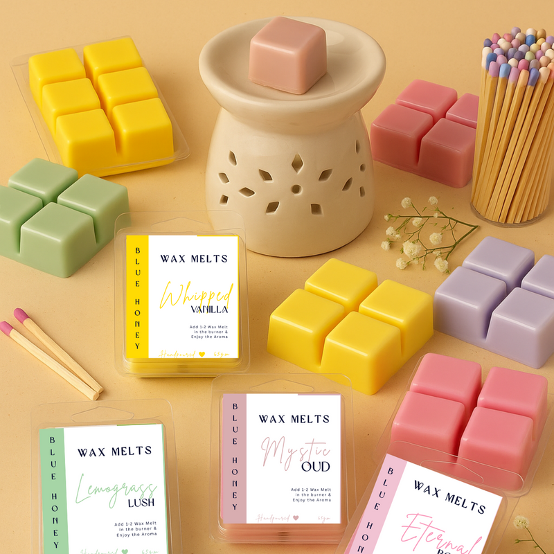 Blue Honey handcrafted wax melts in various colors and scents, displayed with a burner and matches.