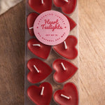 A set of ten red, heart-shaped tea light candles made of soy wax, presented in a clear plastic box.