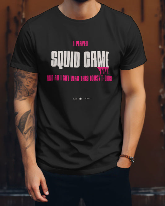 A male model wearing a black t-shirt with the quote 'I Played Squid Game and All I Got Was This Lousy T-Shirt'