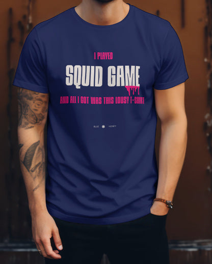 A male model wearing a navy blue t-shirt with the quote 'I Played Squid Game and All I Got Was This Lousy T-Shirt'