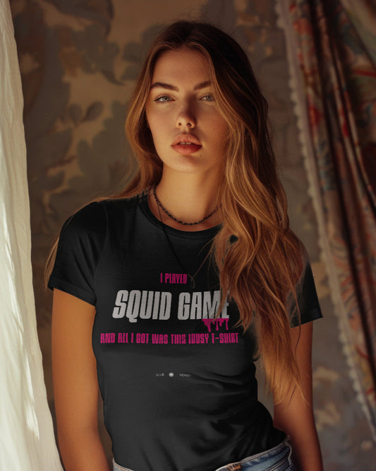 A white female model wearing a black t-shirt with the quote 'I Played Squid Game and All I Got Was This Lousy T-Shirt'