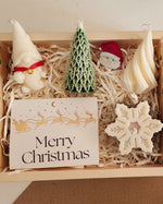 Christmas gift set featuring soy wax mould candles and cement art, including gnome, tree, Santa, and snowflake designs.