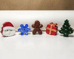Hand-painted miniature cement art Christmas figures including Santa, snowflake, gingerbread man, gift, and tree, perfect for festive decor.