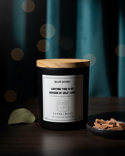 Candle with a wooden lid on a dark surface with a blurred background