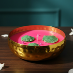 A 4-inch hammered urli soy wax candle with pink wax and green lotus leaf embeds.