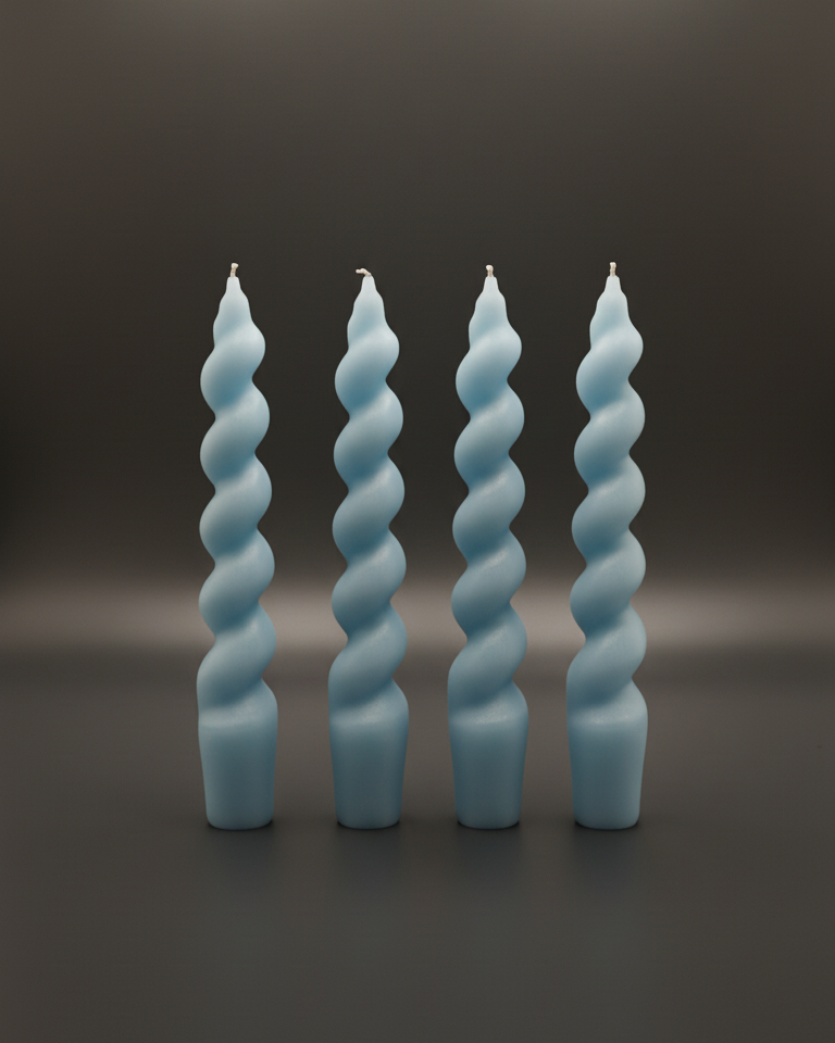 Set of four light blue spiral taper candles standing upright on a dark surface, front view.
