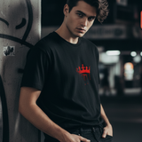 Man wearing a black 'Wear the Crown. Own the Hype - King' unisex crew t-shirt with a red crown graphic.