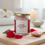Jar of rose relaxing bath salt with rose petals and a wooden spoon on a cutting board.