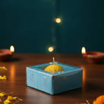A yellow Motichoor Laddoo floating candle in a blue gift box, perfect for Diwali celebrations.