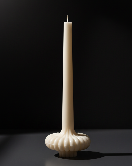 White candle in a decorative holder on a black background