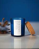 Blue frosted soy wax candle with a cork lid, featuring a 'Blue Honey' label with relaxing scents.