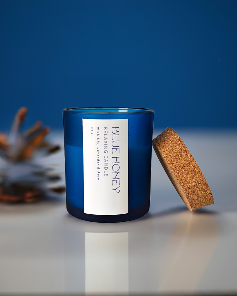 Blue frosted soy wax candle with a cork lid, featuring a 'Blue Honey' label with relaxing scents.