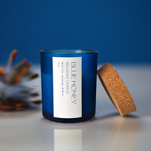 Blue frosted soy wax candle with a cork lid, featuring a 'Blue Honey' label with relaxing scents.